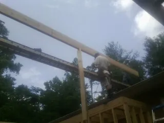 Carpenter setting a ridge beam over a new addition frame — Ice Dam Removal by Roofing Brothers in Mountain City