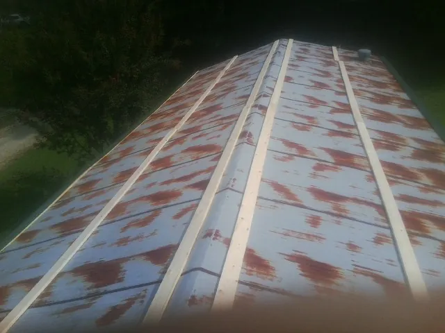 Rusted metal roof panels with new wood purlins before replacement — Storm Damage Roof Repair in Mountain City by Roofing Brothers