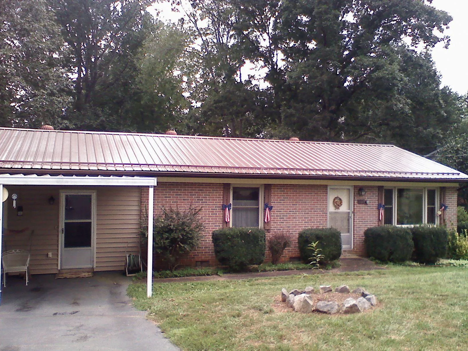 Bronze metal roof and carport on a brick ranch home — Roof Repair work by our crew in Mountain City